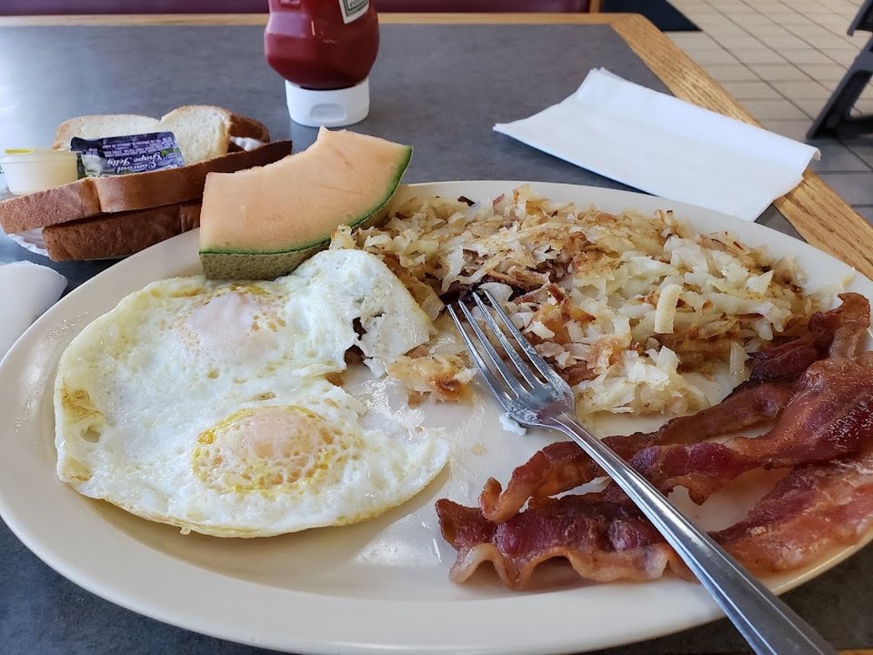 Breakfast plates and sandwiches on a menu board.
