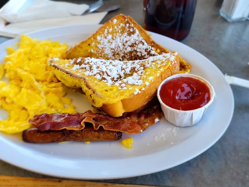 Breakfast plates and sandwiches on a menu board.